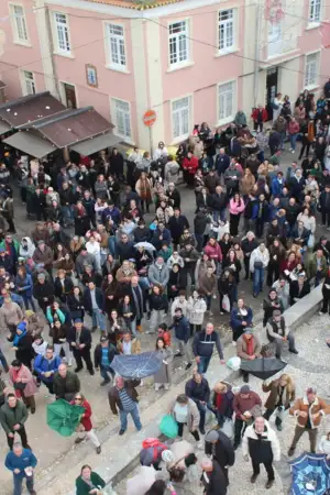 Dezenas de pessoas no Bairro da Beira-mar em Aveiro a apanhar cavacas que são lançadas do topo da capela.